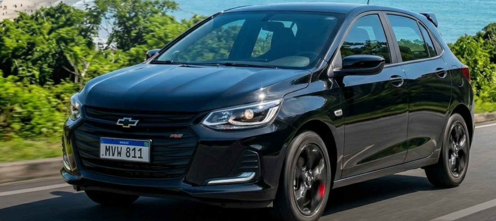 Chevrolet Onix preto da frota Dubai Auto na orla de Balneário Camboriú